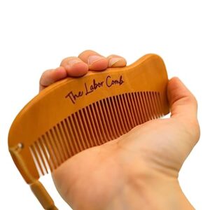 A woman squeezing the labor comb to help manage contraction pain during labor.