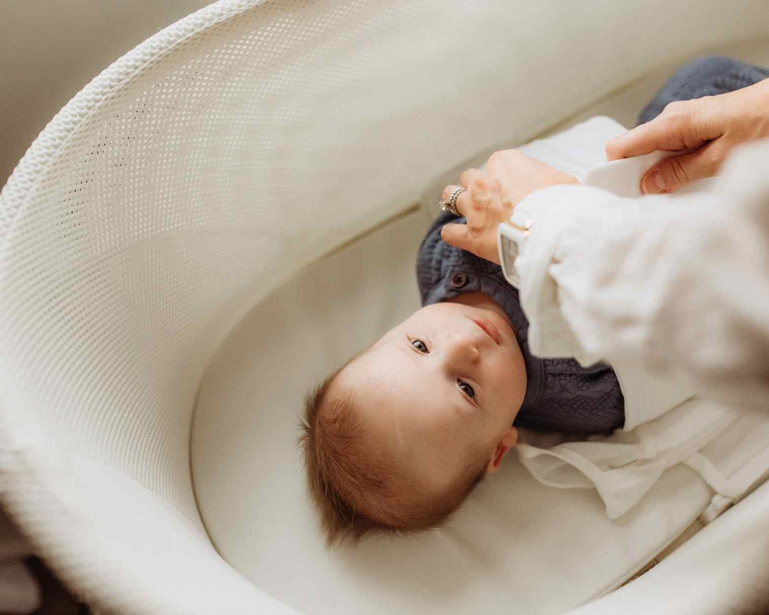 A baby boy in his SNOO bassinet rental getting ready for sleep.