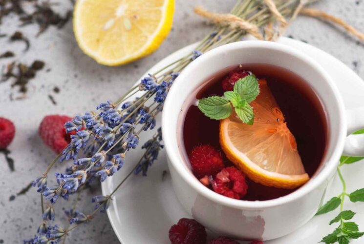 A cup of red raspberry leaf tea with a lemon and lavender.