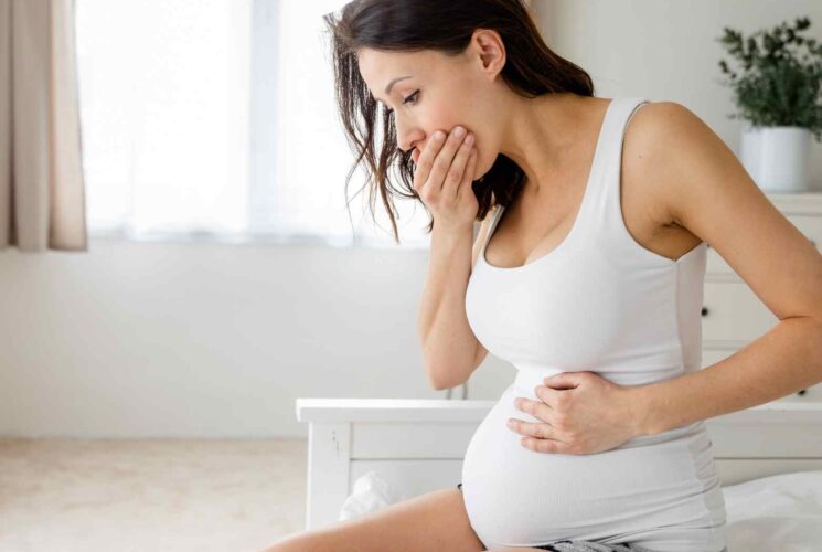 A woman with morning sickness using natural remedies for pregnancy nausea.