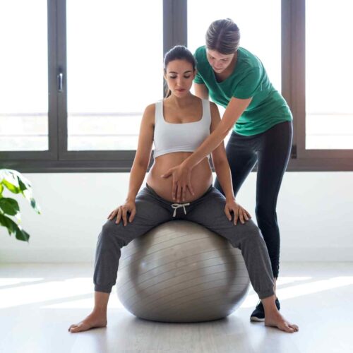 A woman in labor using a birth ball for different labor positions.