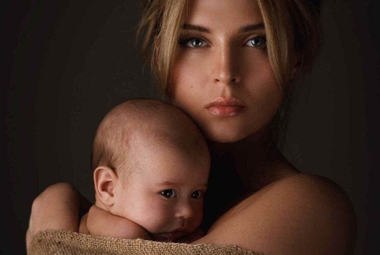 A postpartum woman dealing with her postpartum hormones and holding her newborn baby.