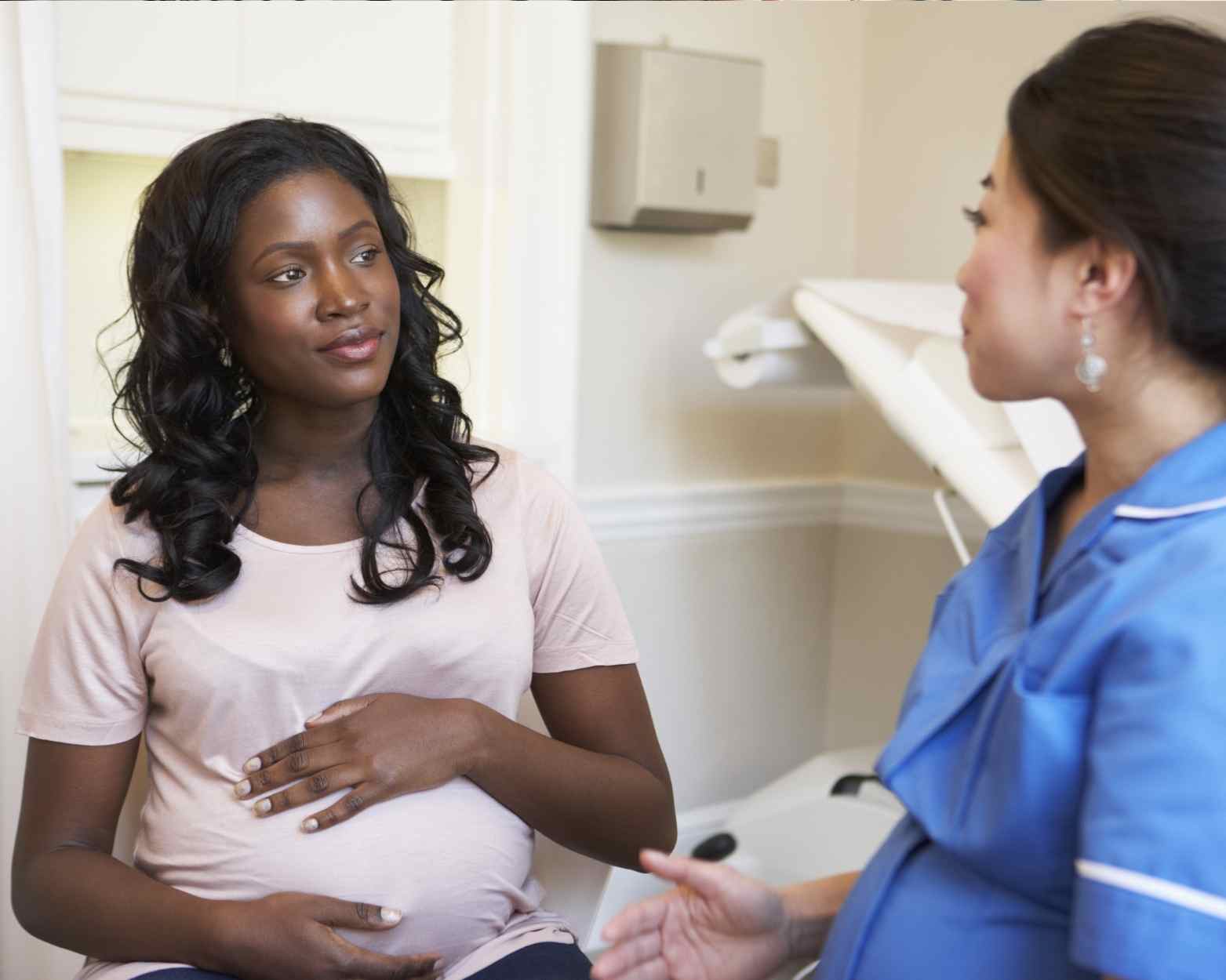 A woman discussing alternative natural labor induction methods with her midwife.
